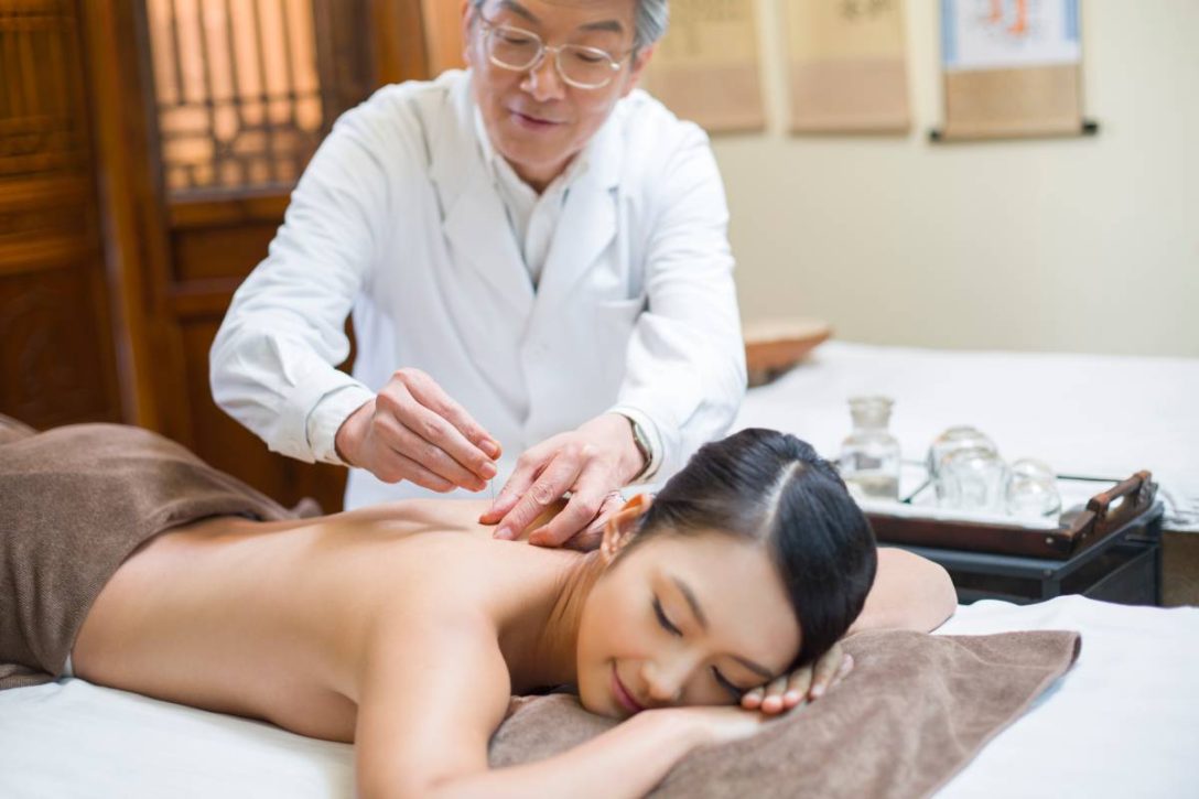 Young Chinese woman receiving acupuncture